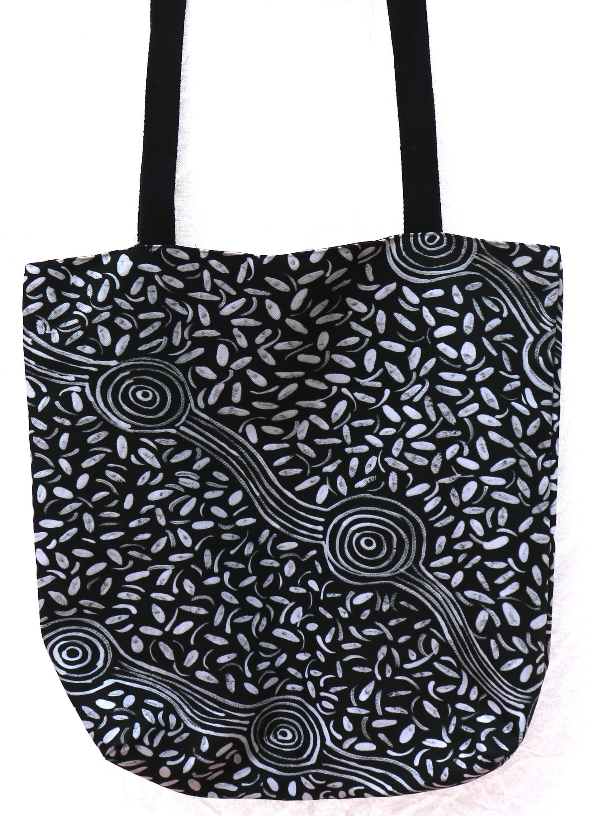 A black and white tote bag with a floral pattern on it.