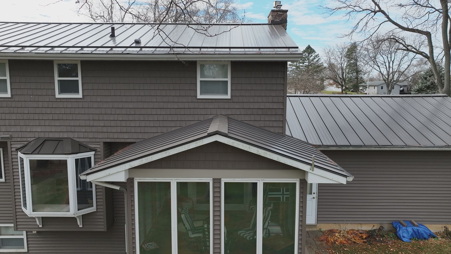 Modern metal roof installation on a sunroom and multi-level house in Middleton WI.