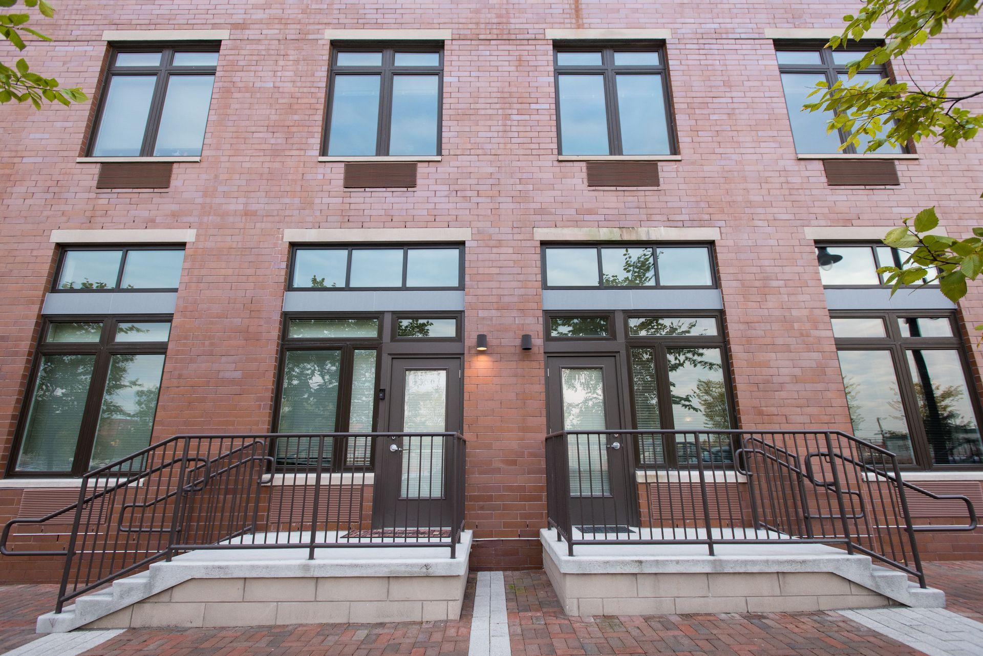 A brick building with stairs leading up to the front door