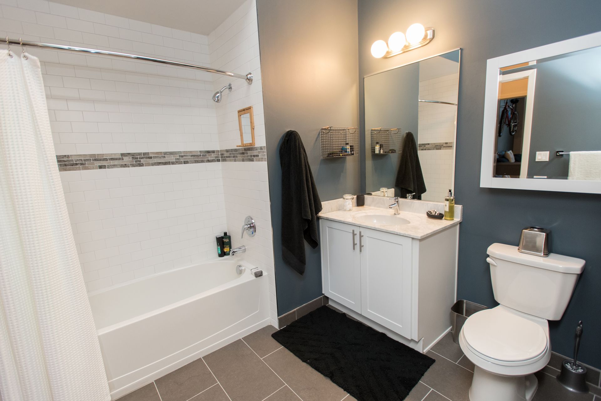 A bathroom with a toilet , sink , bathtub and mirror.