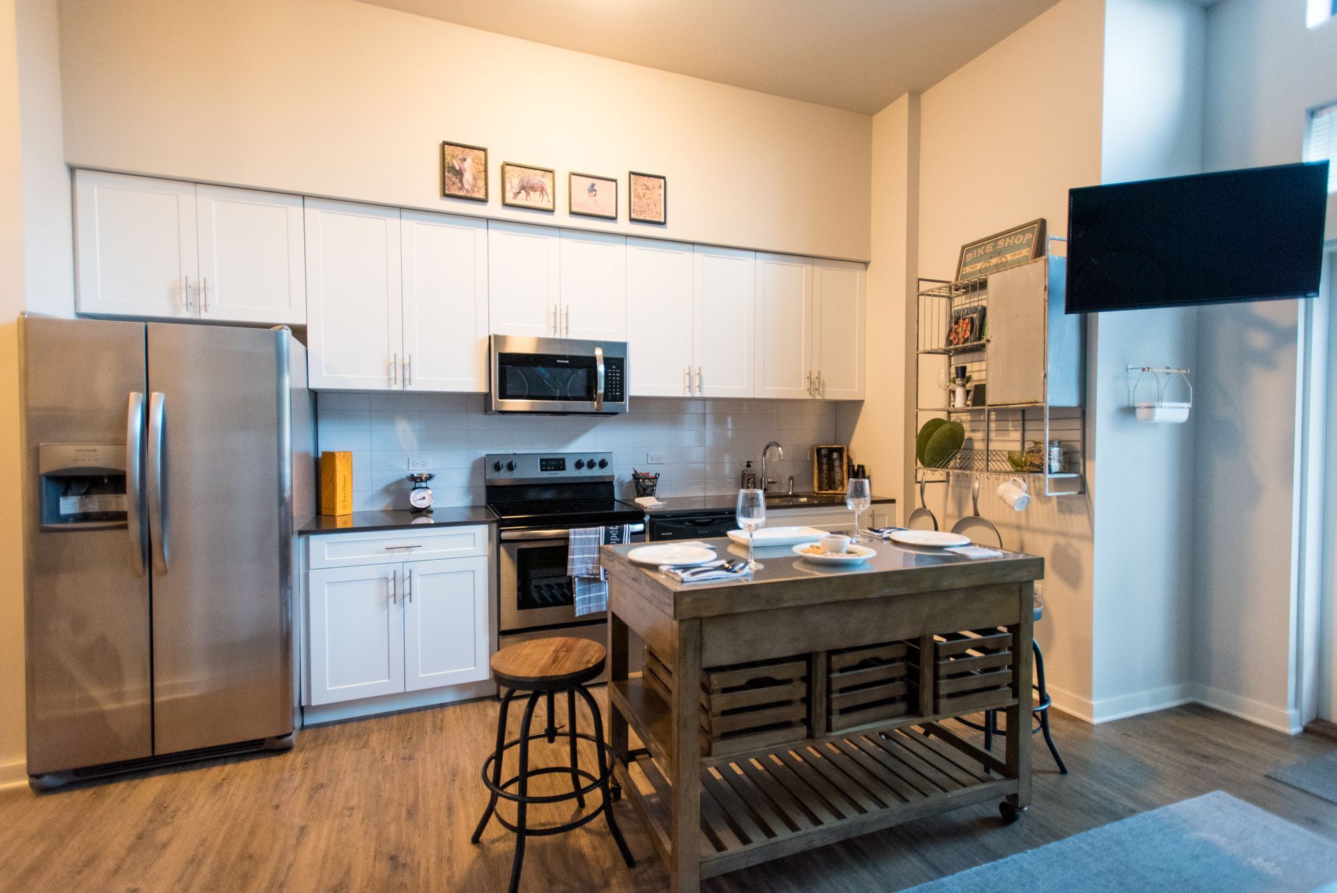 A kitchen with stainless steel appliances and a wooden island.