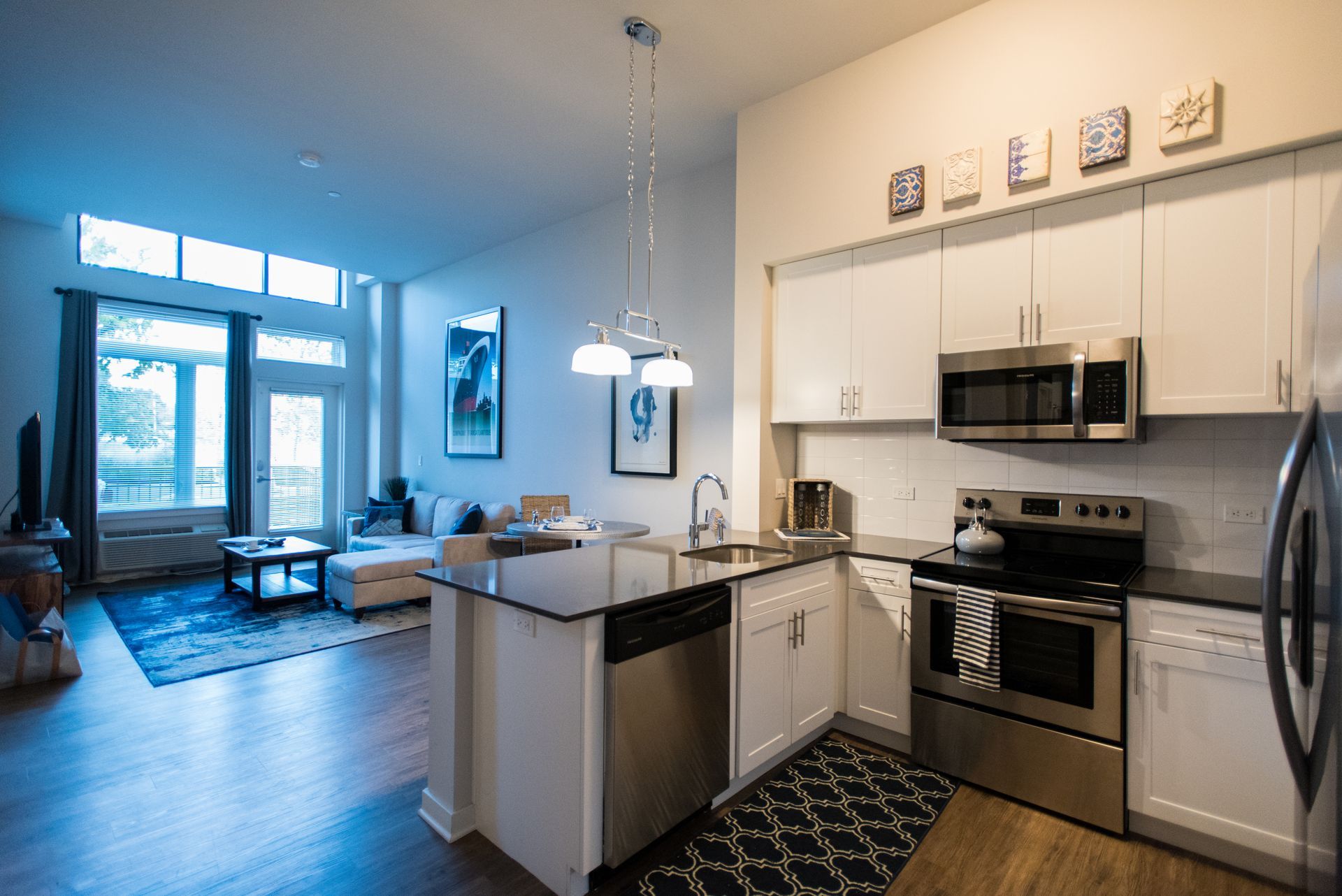 A kitchen in a house with stainless steel appliances and white cabinets.
