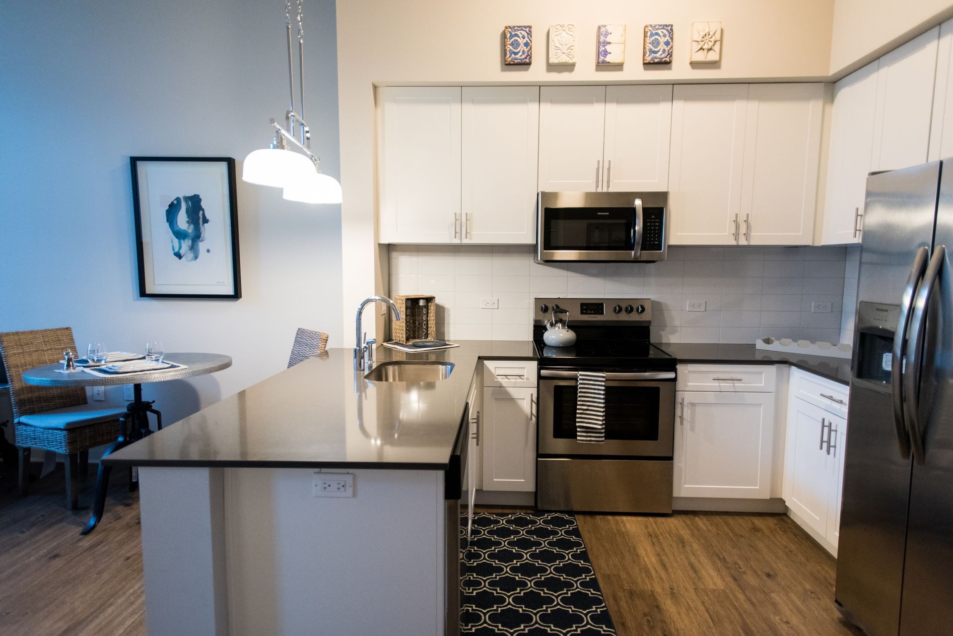 A kitchen with stainless steel appliances and white cabinets.