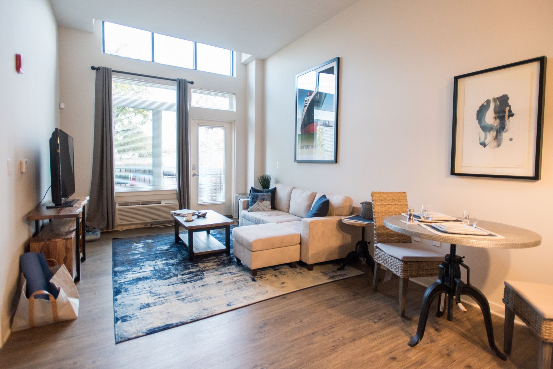 A living room with a couch , table , chairs and a television.