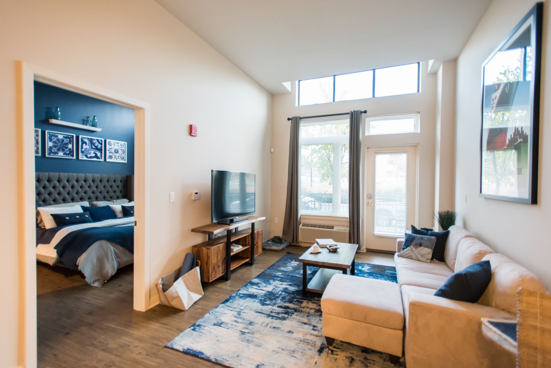 A living room with a couch , television , and a bed.
