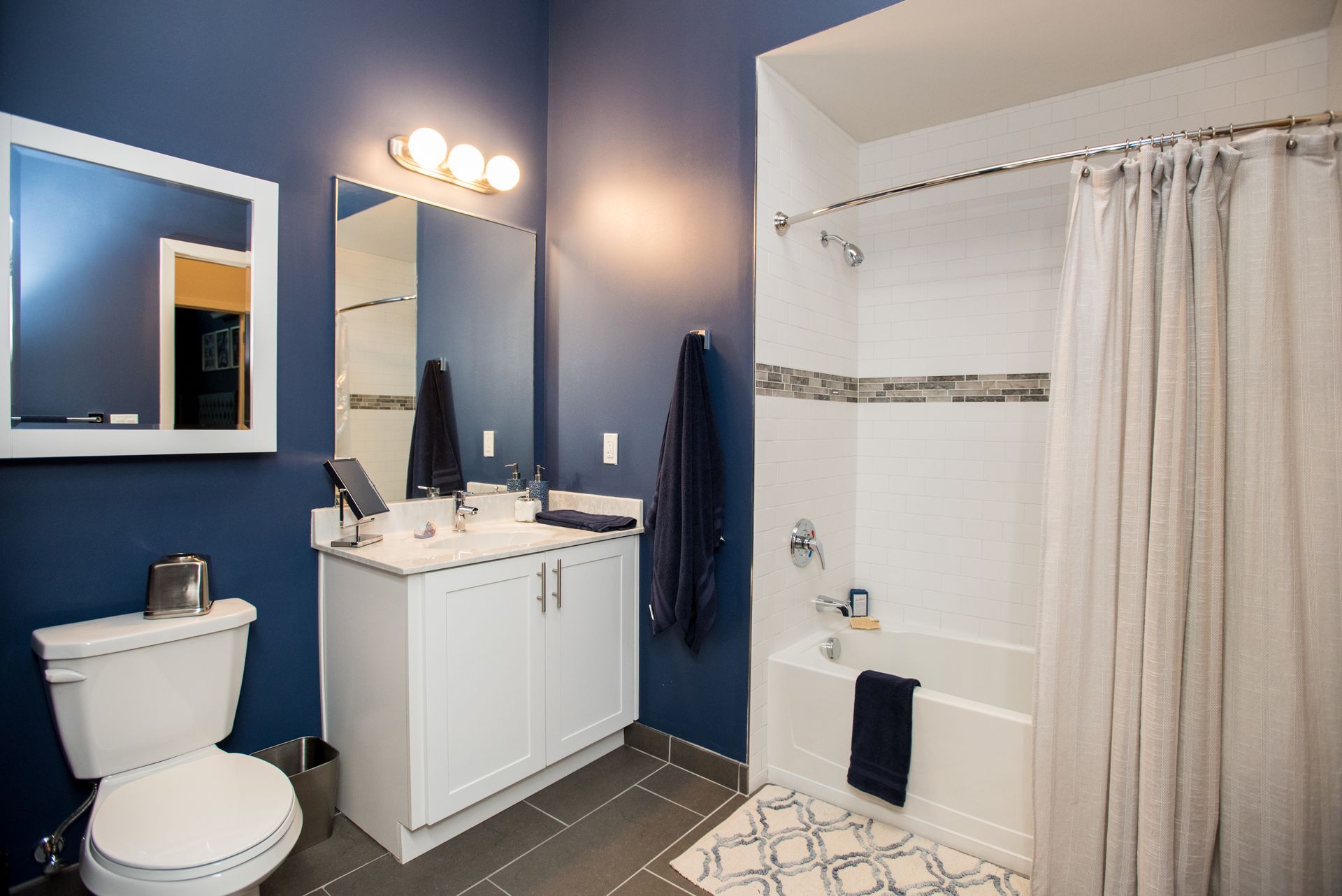 A bathroom with a toilet , sink , mirror and bathtub.