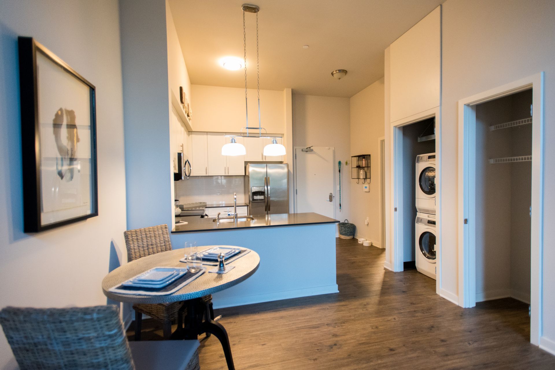 A kitchen with a table and chairs and a washer and dryer.