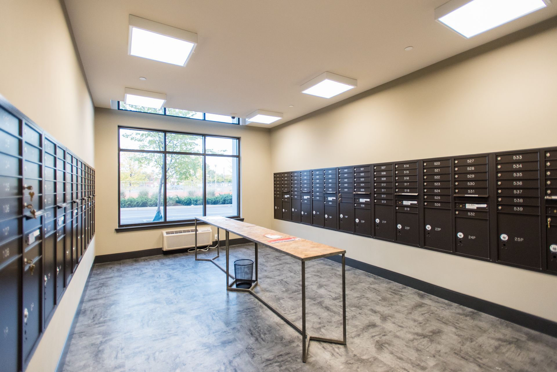 A mail room with lots of mailboxes and a table.
