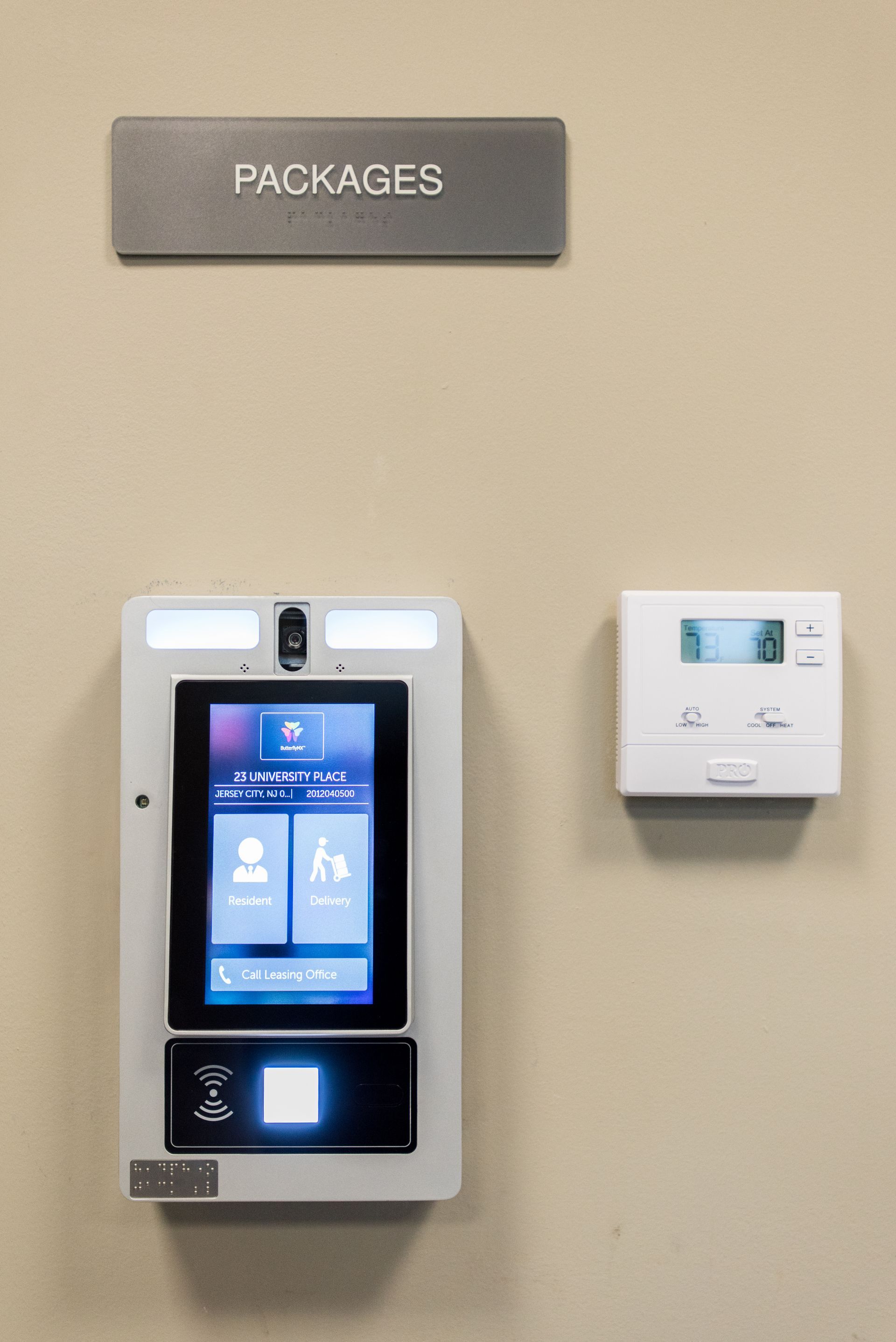 There is a packages sign on the wall next to a thermostat.