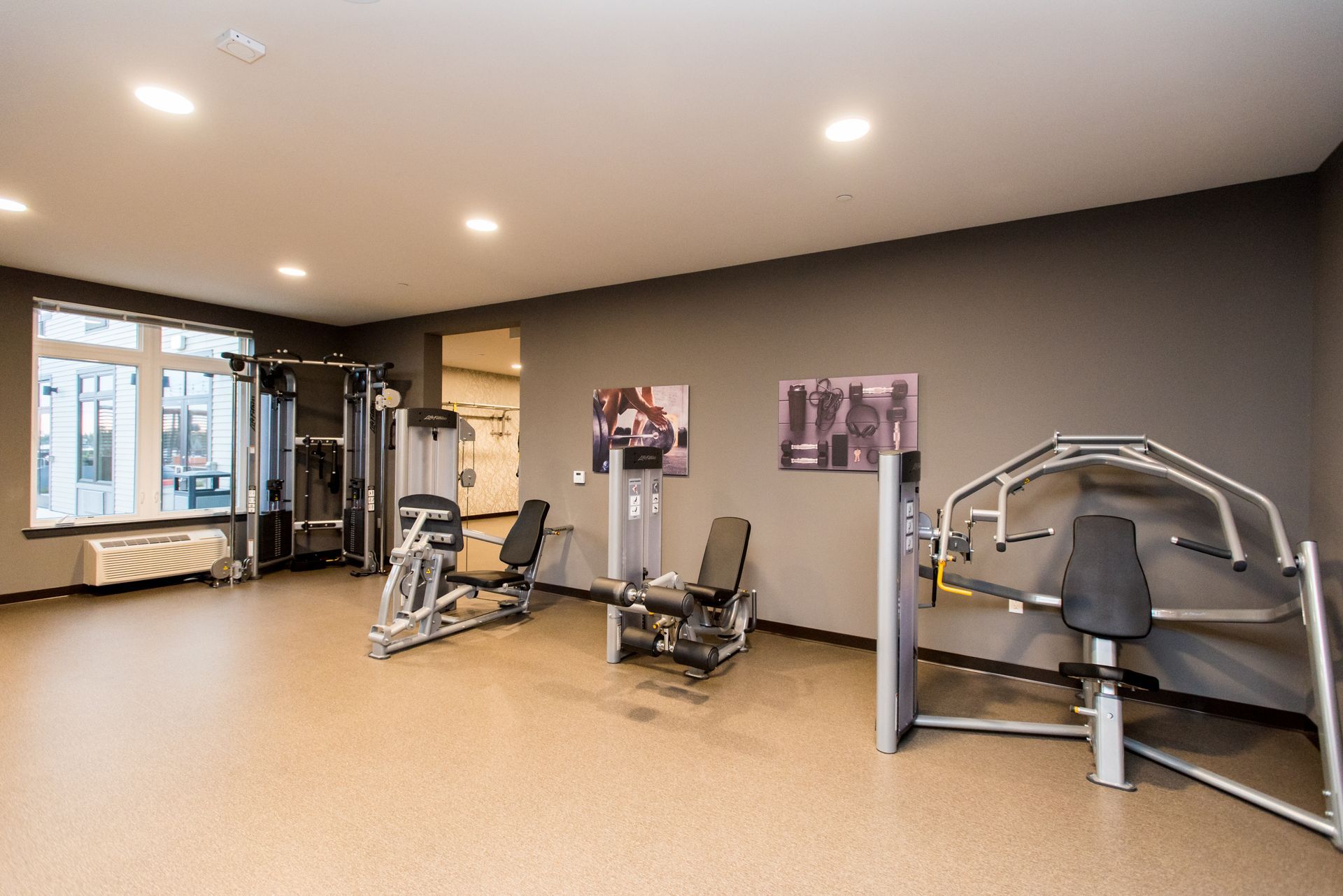 A large empty gym with a lot of exercise equipment.