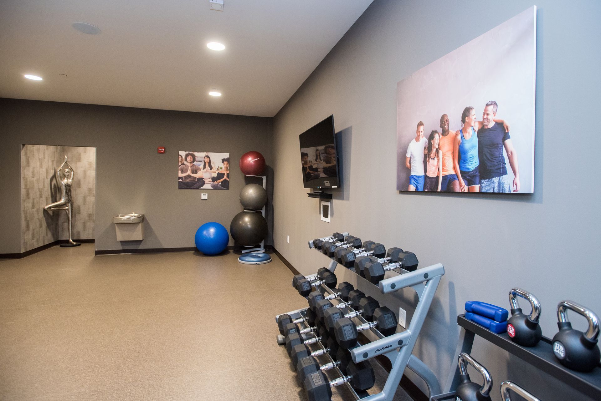 There is a picture of a group of people on the wall in the gym.