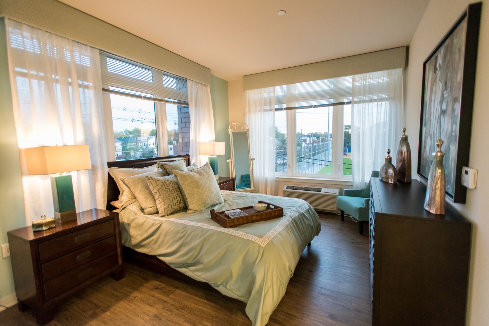A bedroom with a bed , dresser , nightstand , chair and window.