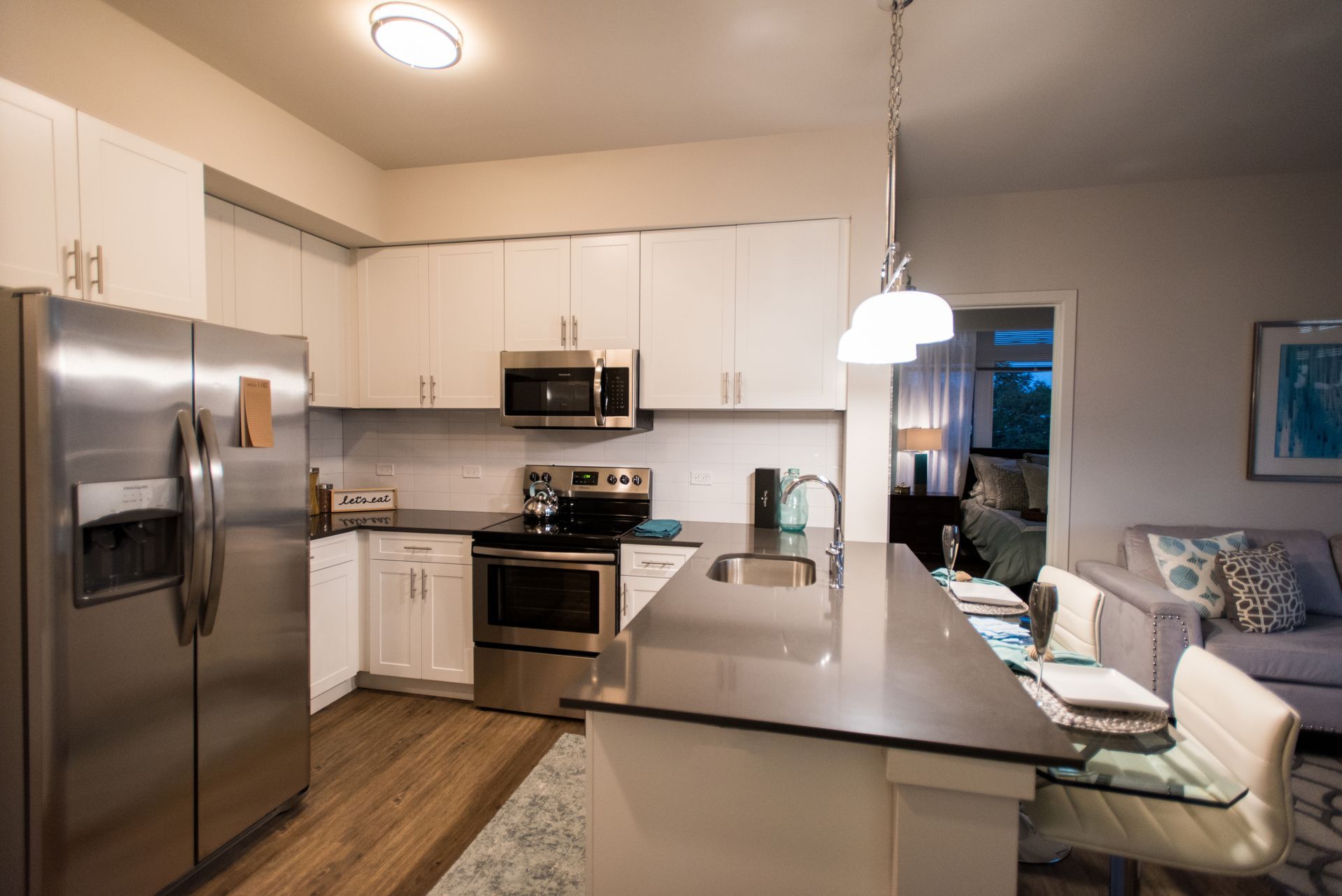 A kitchen with stainless steel appliances and white cabinets.