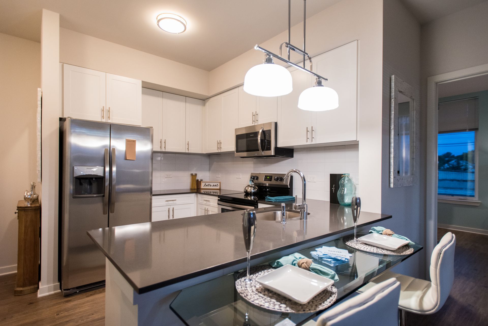 A kitchen with stainless steel appliances and a glass table.