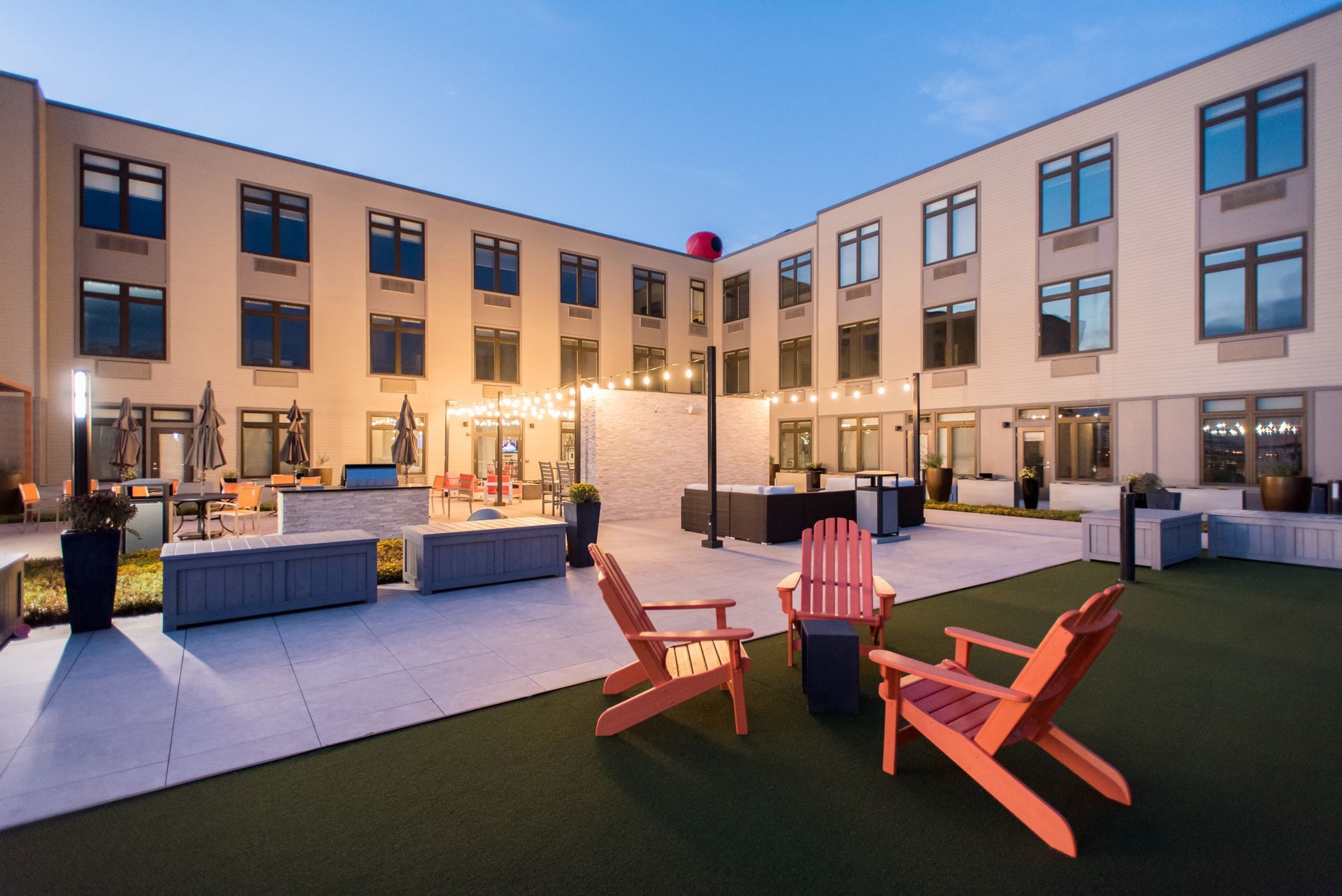 Two wooden chairs are sitting in front of a large building.
