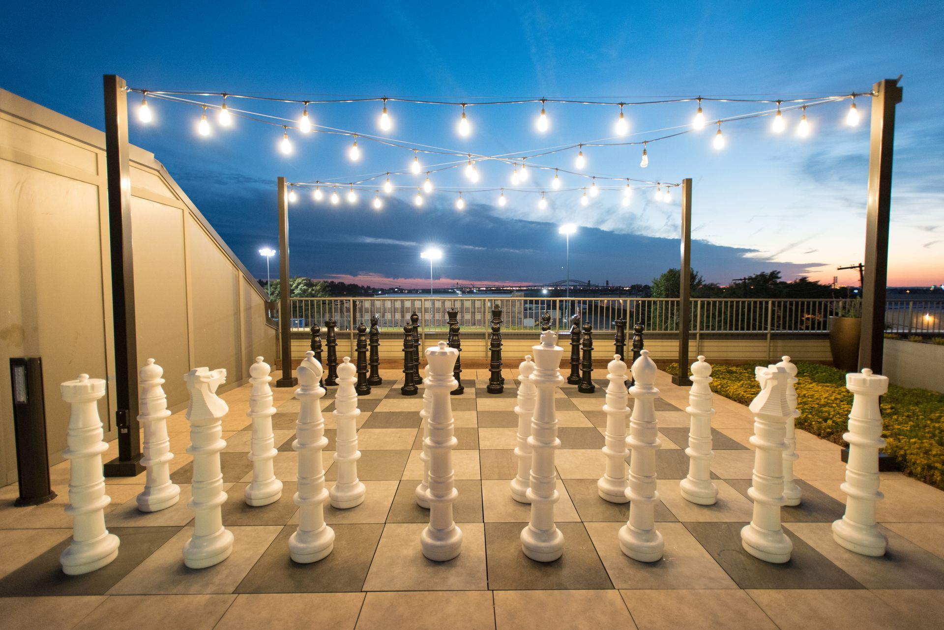 A large chess board with giant chess pieces on it.