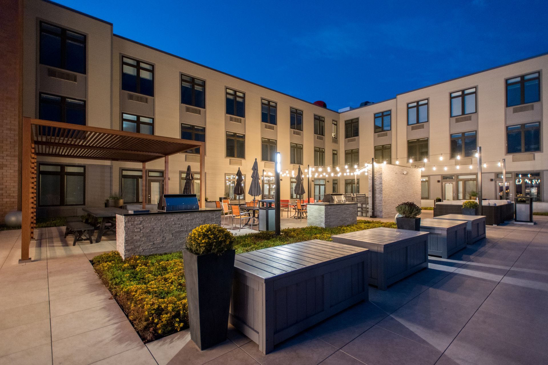 A large building with a courtyard in front of it at night.