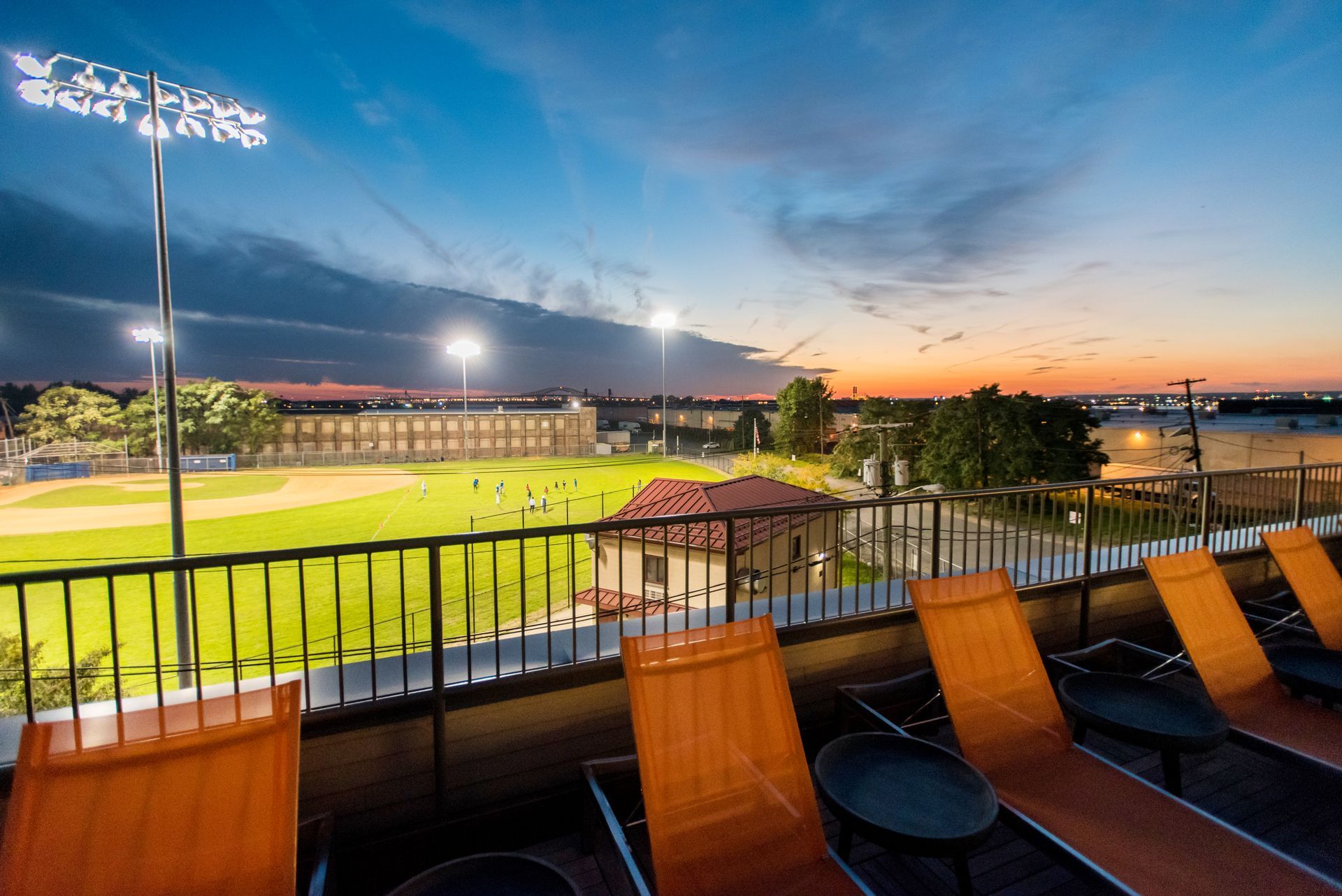 A view of a baseball field from a balcony at night.