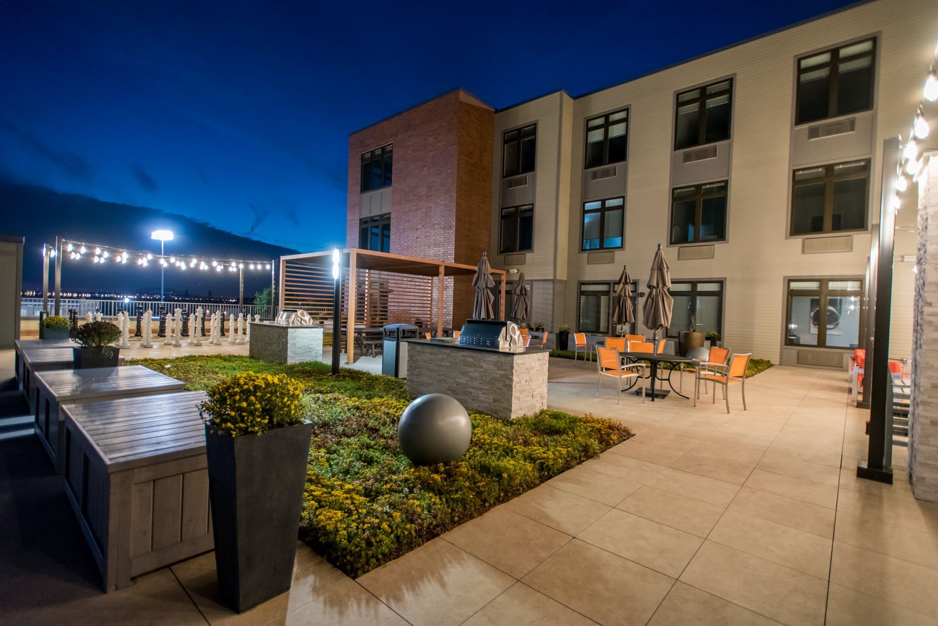 A large building with a patio in front of it at night.