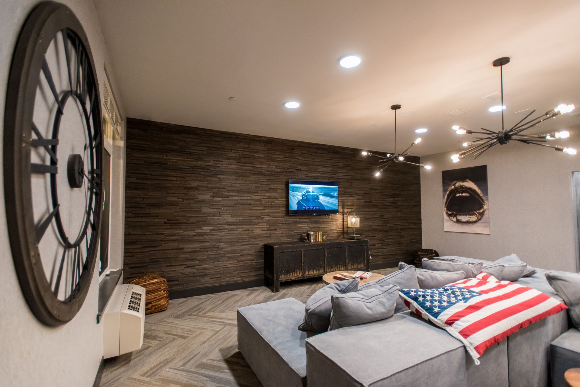 A living room with a couch and a television on the wall.