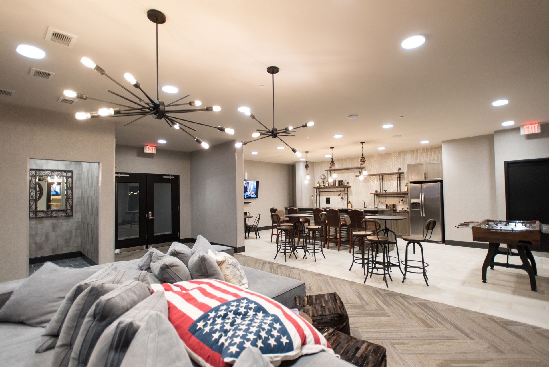 A living room with a couch and a pillow with an american flag on it.