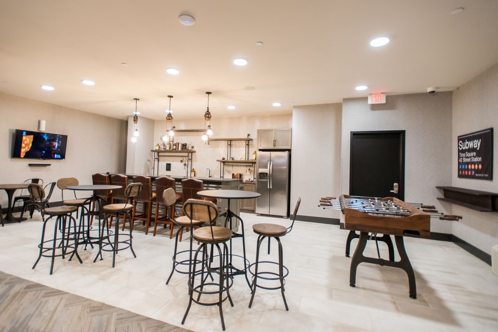 A room with tables and chairs and a foosball table.