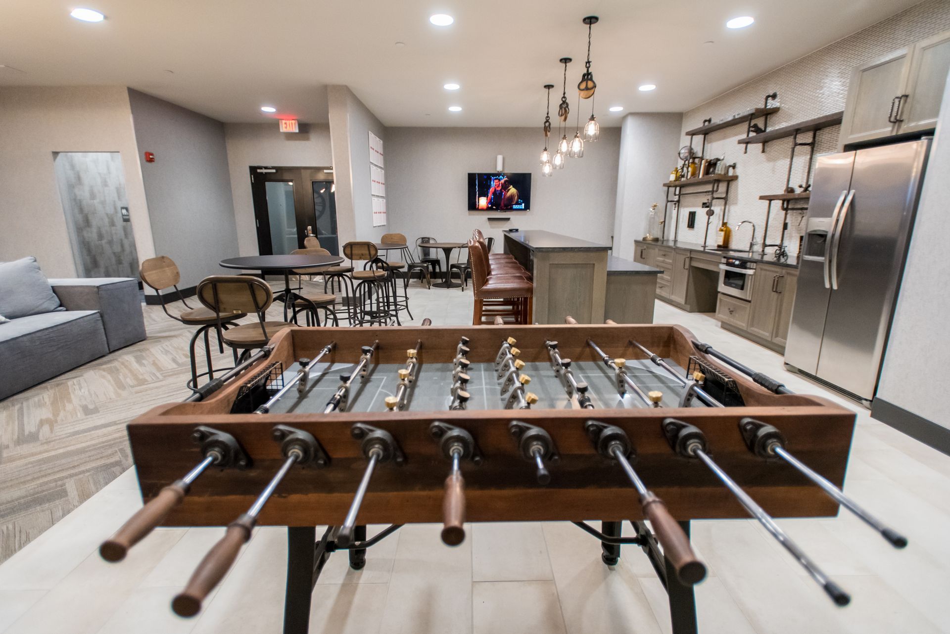 A foosball table is sitting in a room with tables and chairs.
