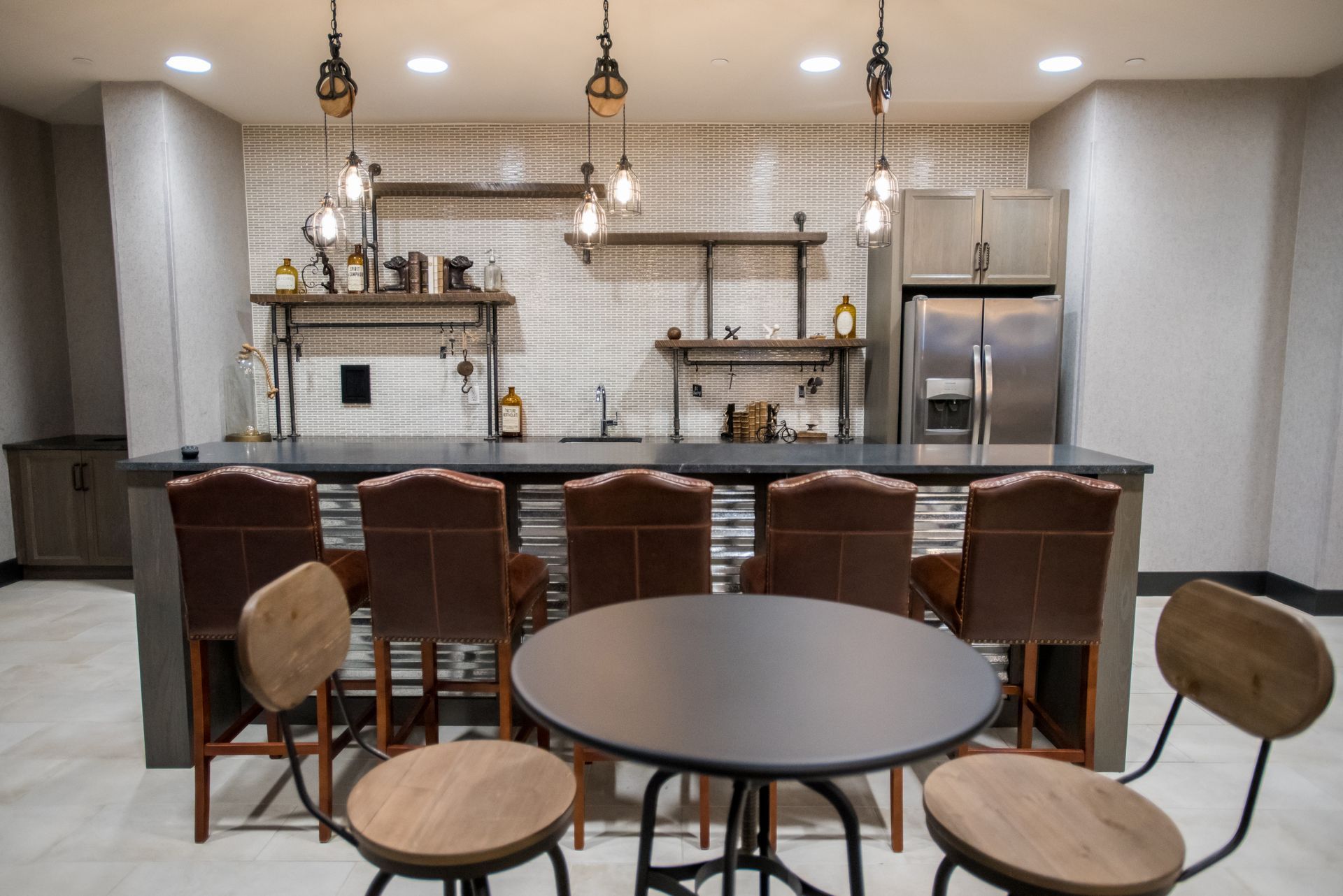 A kitchen with a table and chairs and a refrigerator.