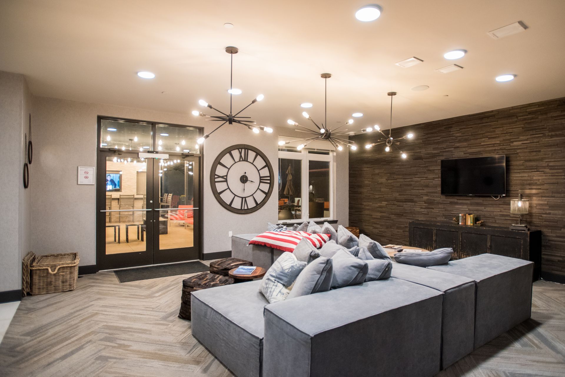 A living room with a couch and a clock on the wall.