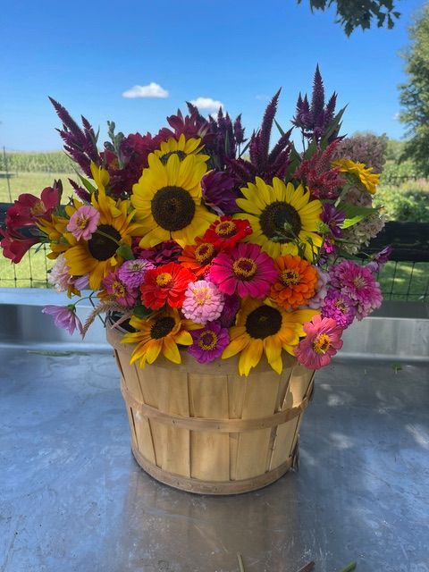 A basket filled with sunflowers and other flowers
