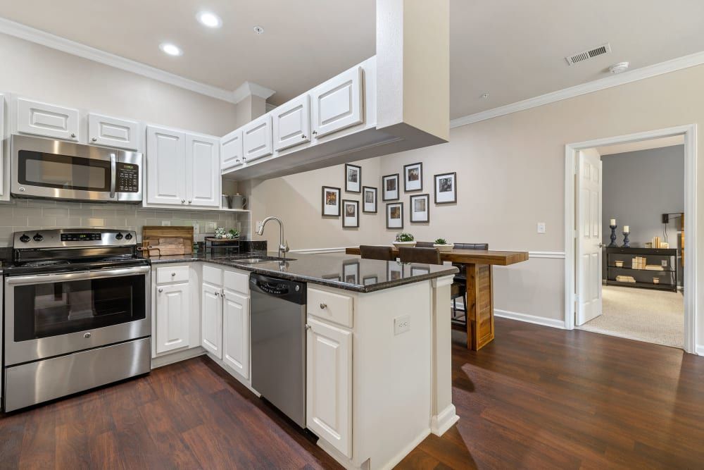 a kitchen with stainless steel appliances and white cabinets at Marquis Carmel Commons in Charlotte, NC.