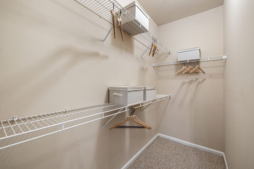 a walk-in closet with a lot of shelves and hangers at Marquis Carmel Commons in Charlotte, NC.