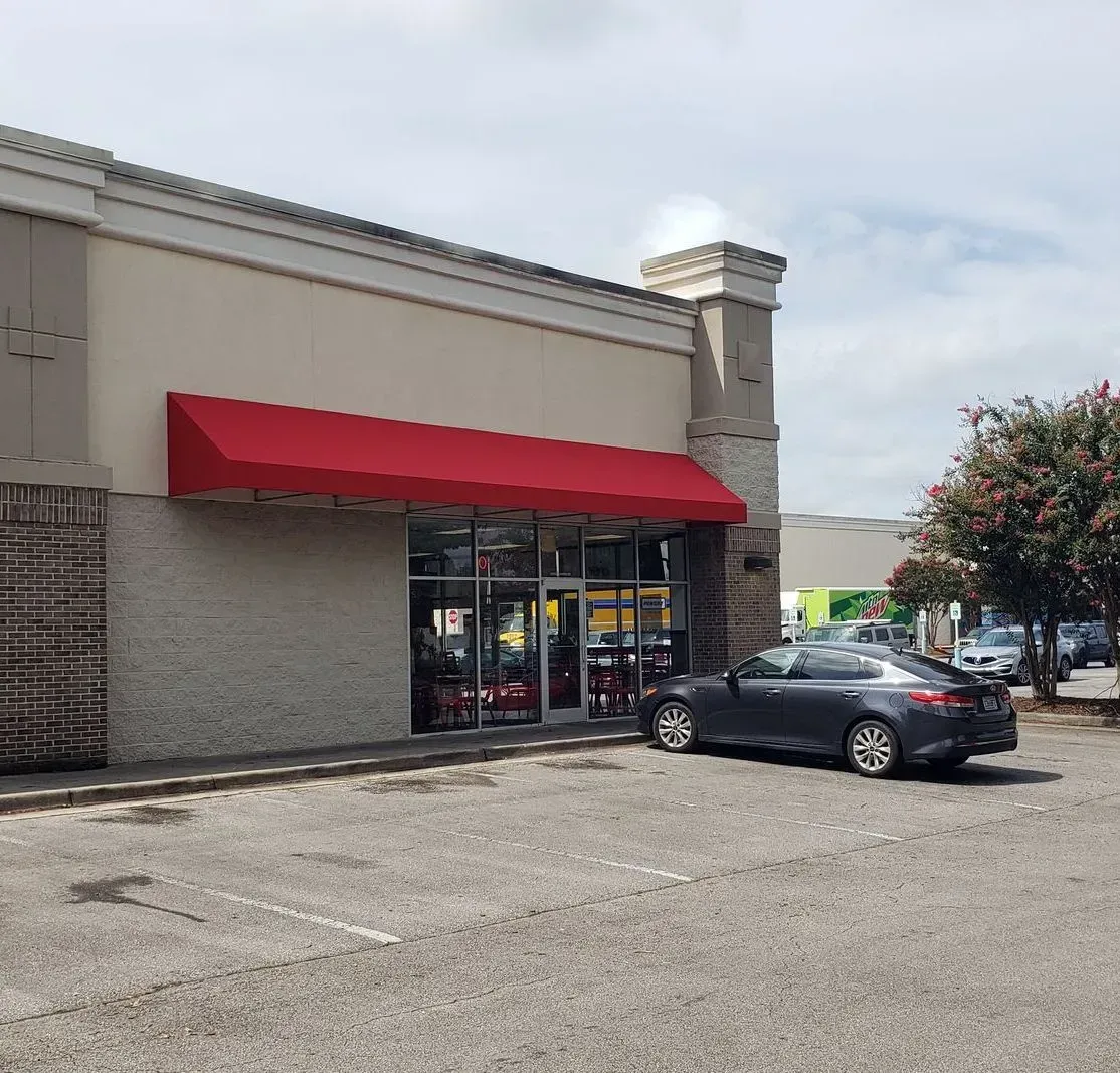 Car Parked in Front of a Store with Red Awning — Decatur, AL — Evans Awnings