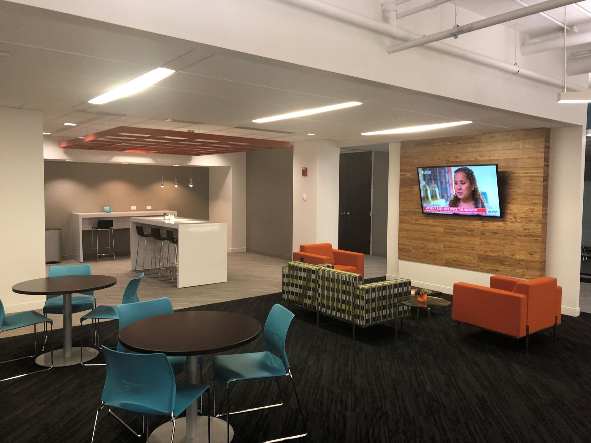 A living room with tables and chairs and a flat screen TV