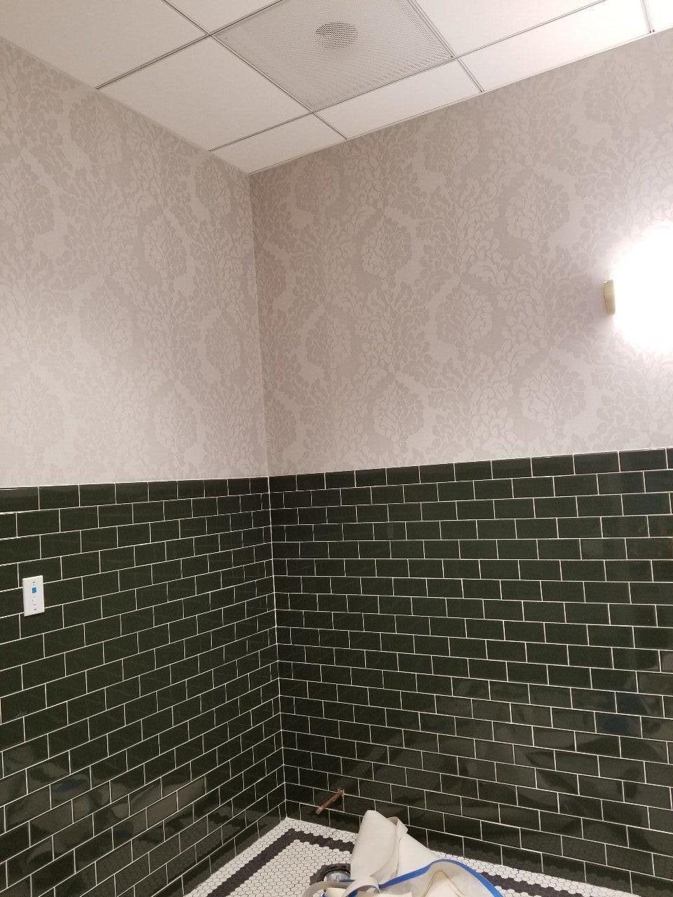 A bathroom with a brick wall and a tile floor