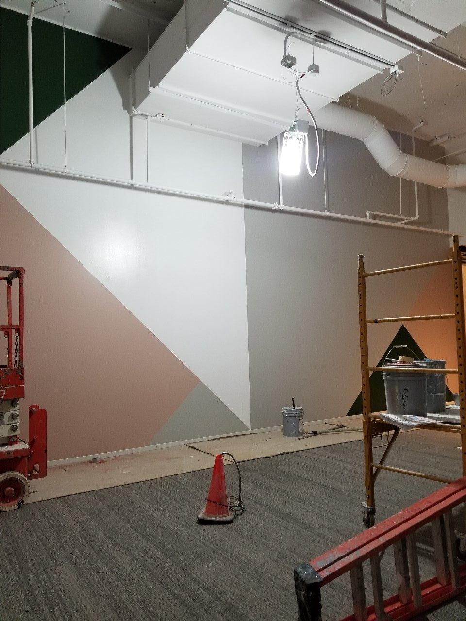 A room with a ladder and a cone on the floor