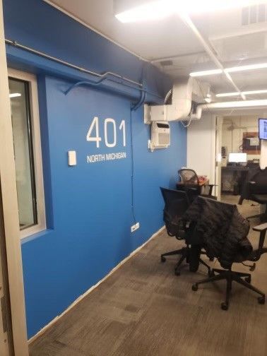 A room with blue walls and chairs and the number 401 on the wall.