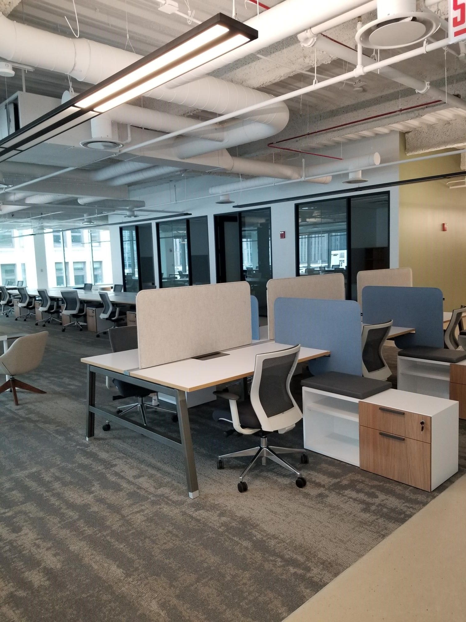 A large office with a lot of desks and chairs.