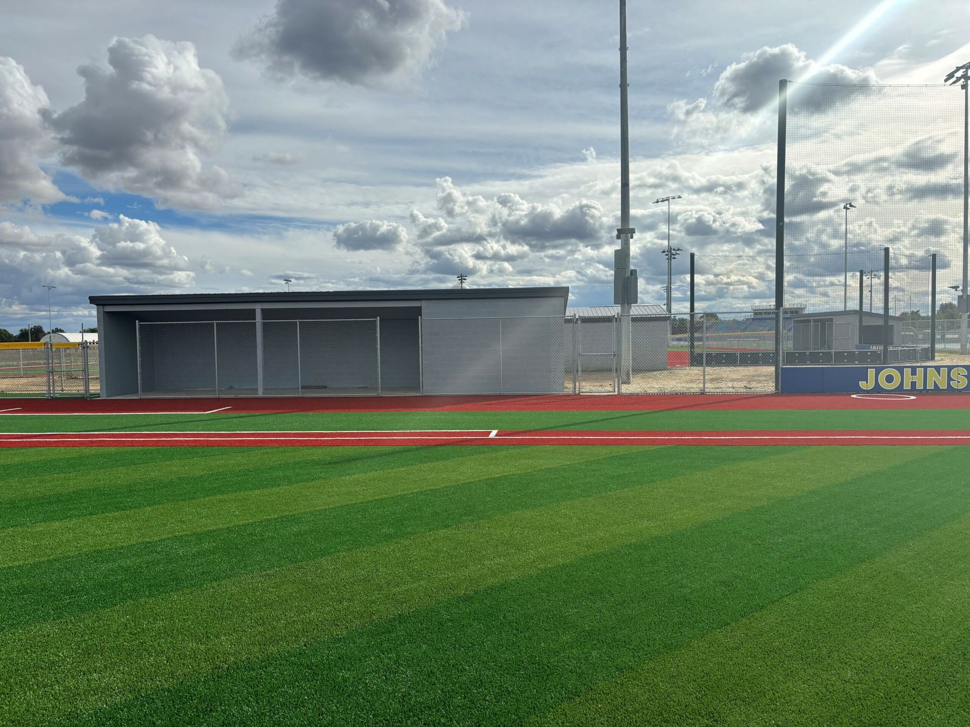 A baseball field with a shelter on the side of it.