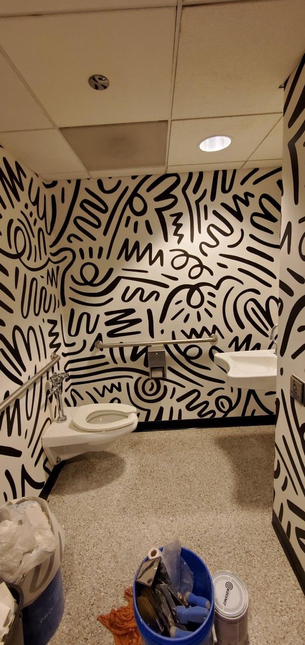 A bathroom with a black and white mural on the wall.