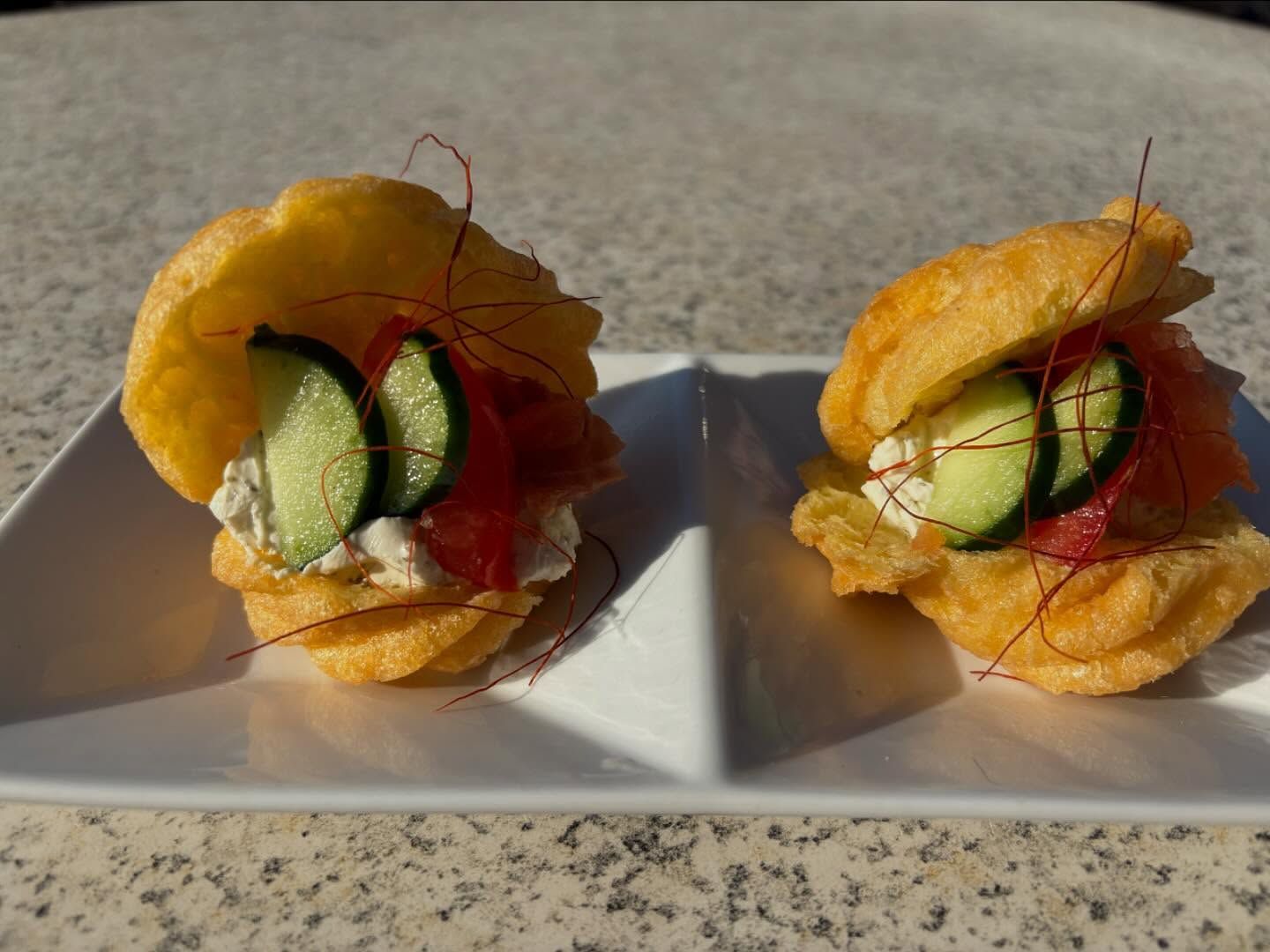Due panini sono su un piatto bianco su un tavolo.