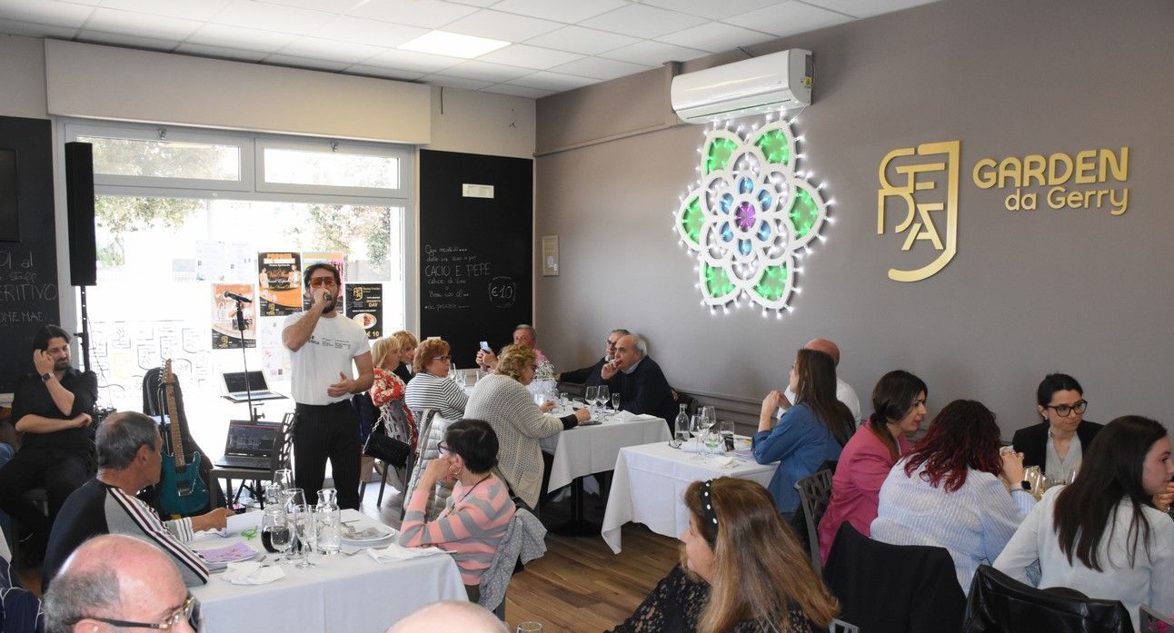 Un gruppo di persone è seduto ai tavoli di un ristorante.