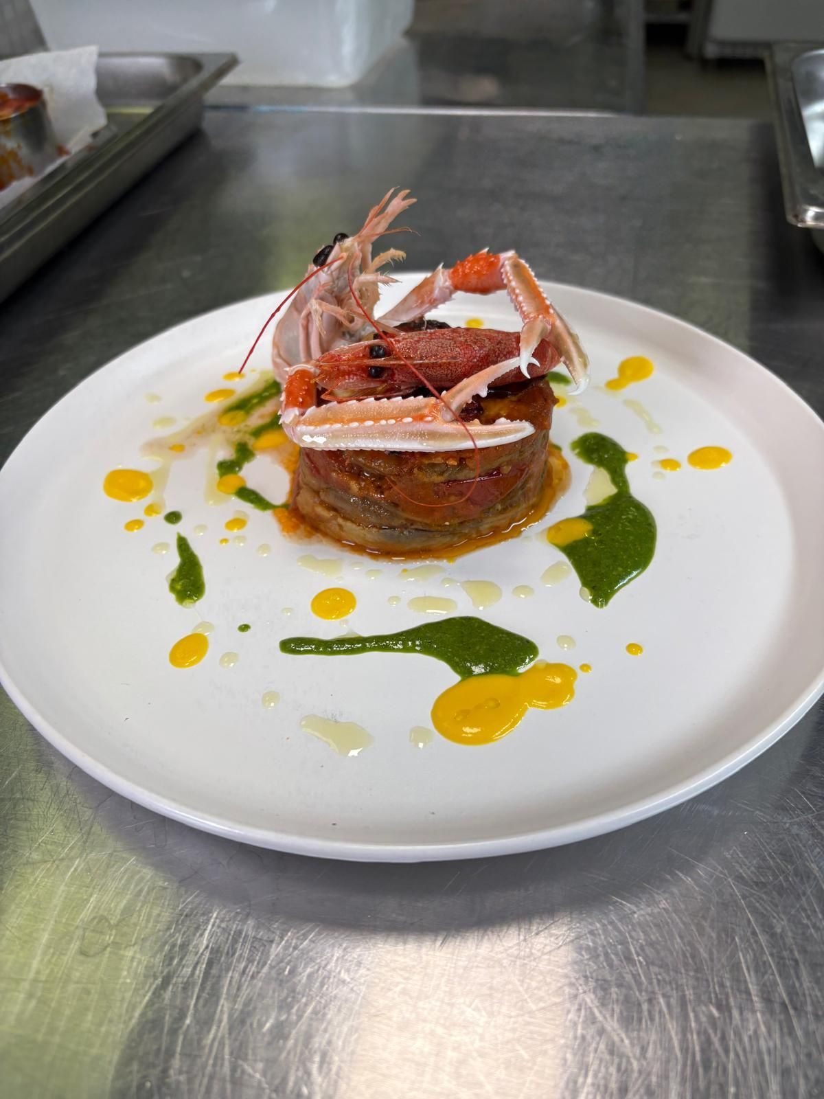 Un piatto bianco con un granchio sopra su un tavolo.