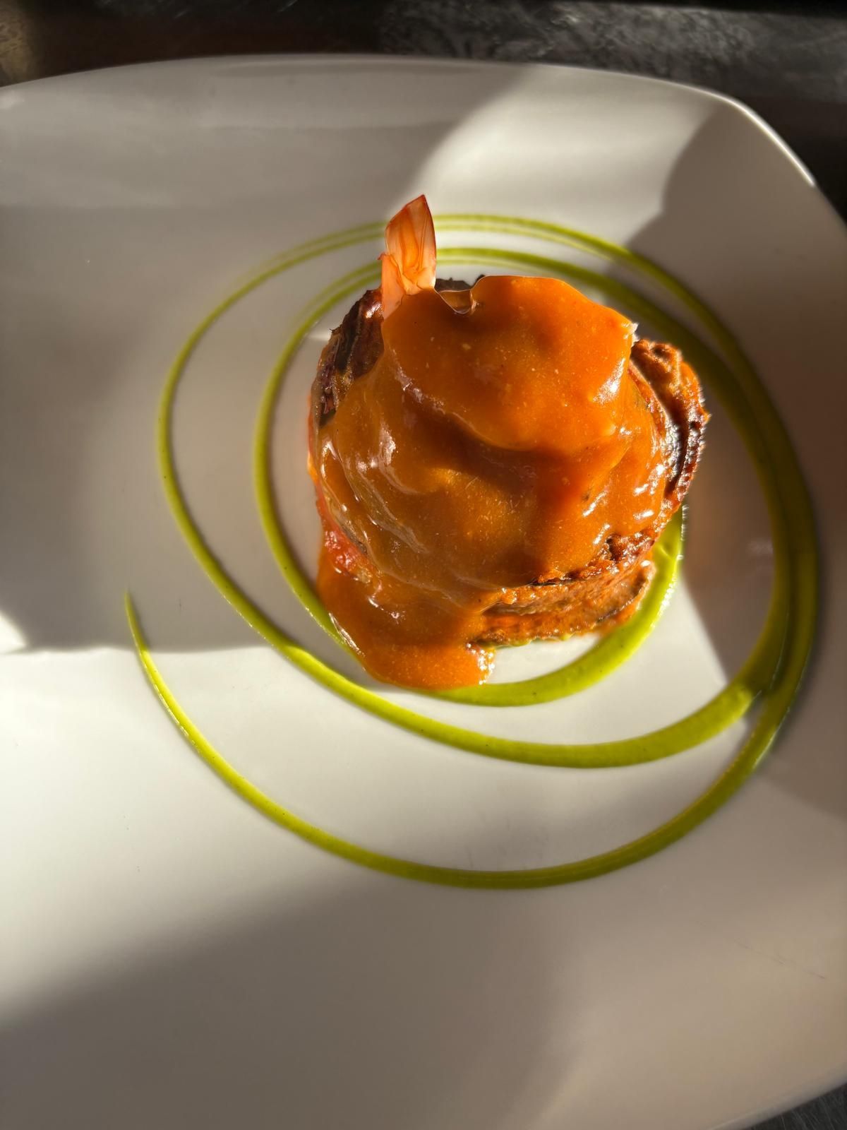 Un piatto bianco condito con gamberi e salsa