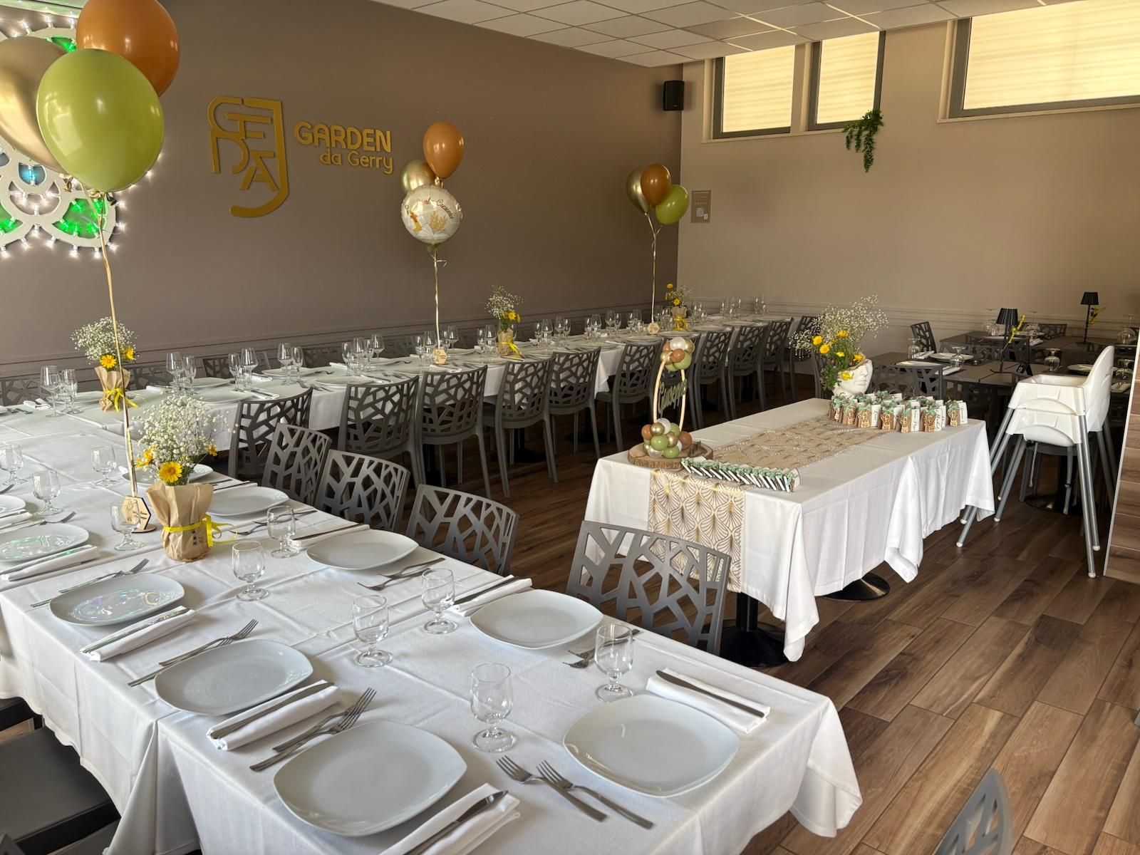 Una grande stanza con tavoli e sedie allestita per una festa.