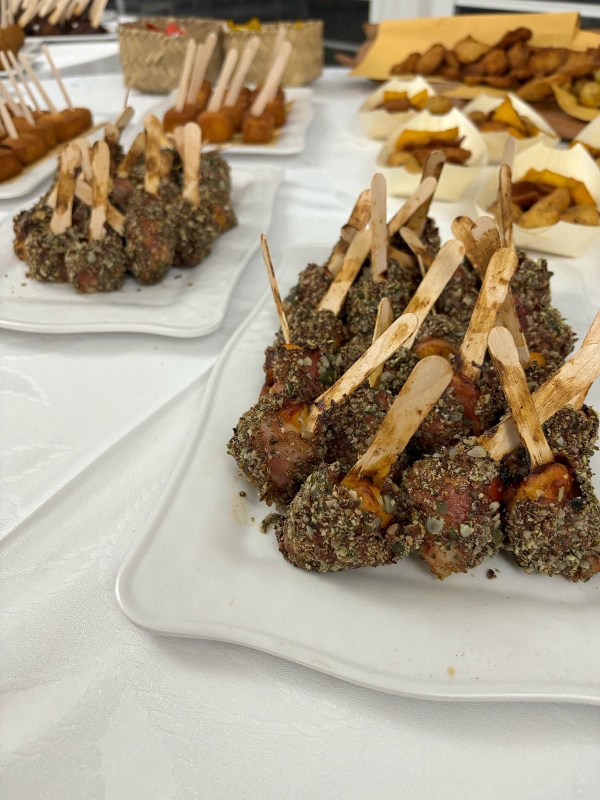 Un piatto bianco sormontato da polpette su stecchi su un tavolo