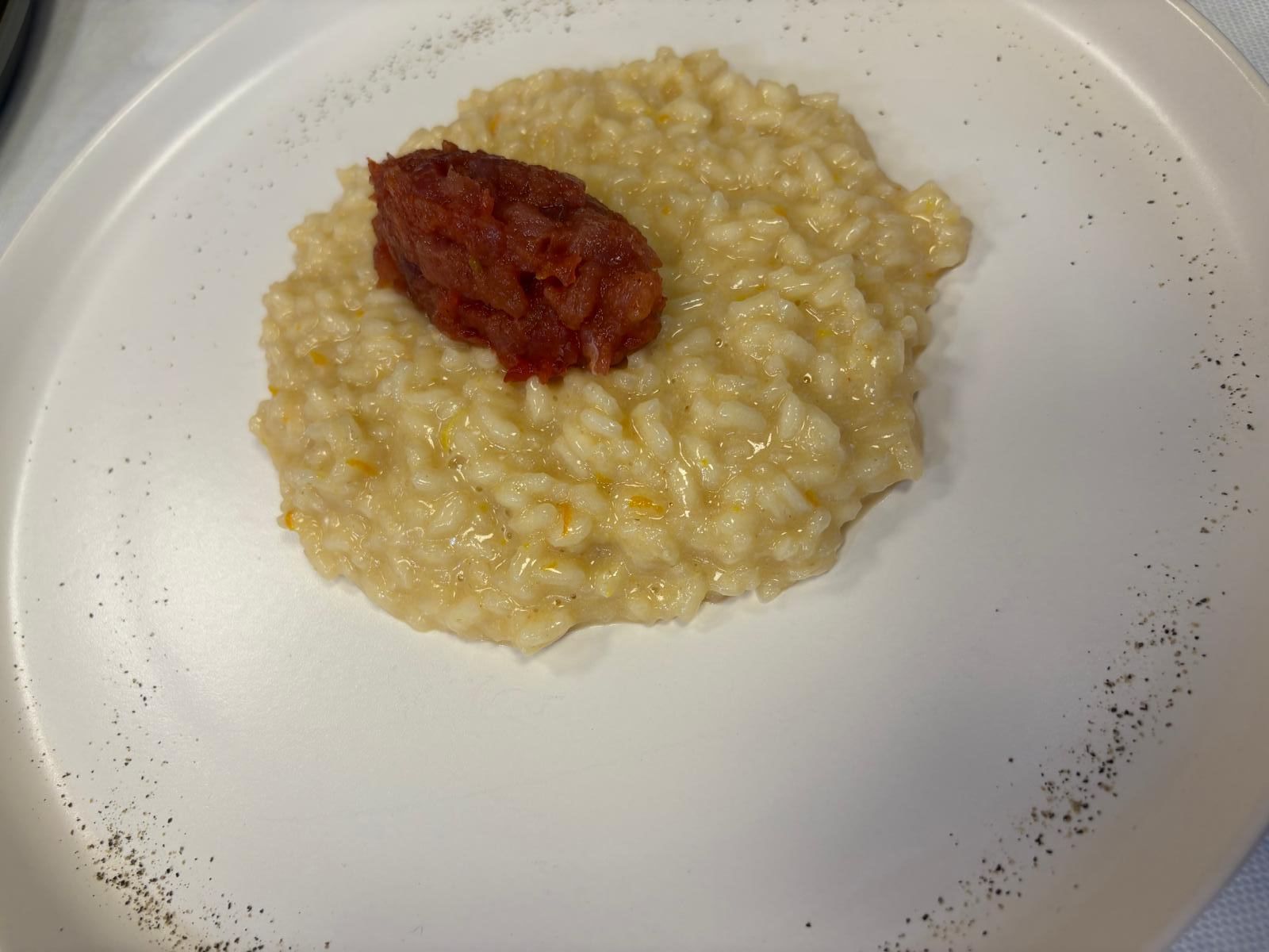 Un piatto bianco con riso e salsa rossa.