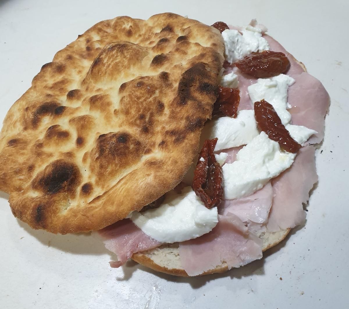 Un primo piano di un panino con prosciutto e formaggio