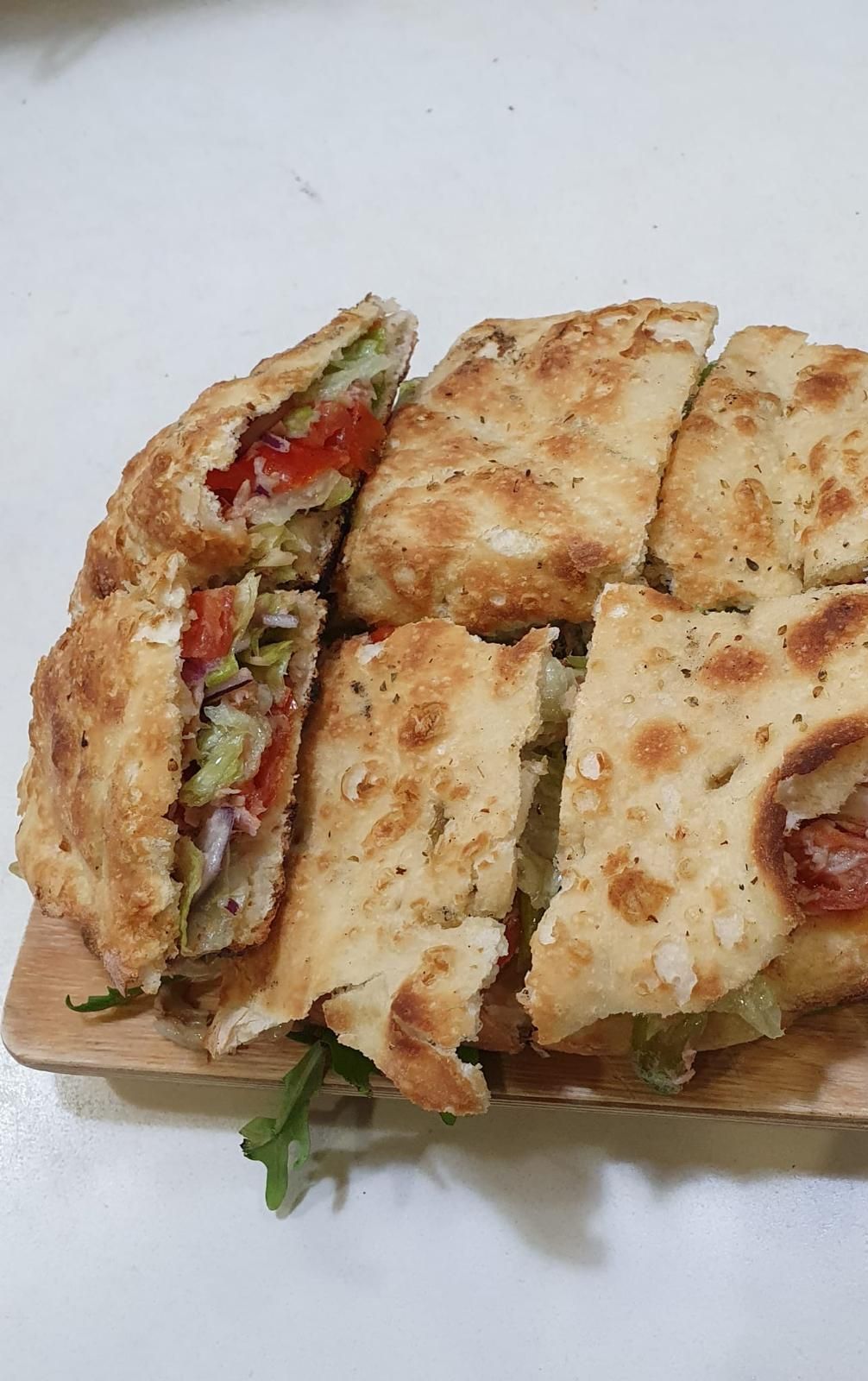 Primo piano di un panino su un tagliere di legno su un tavolo.