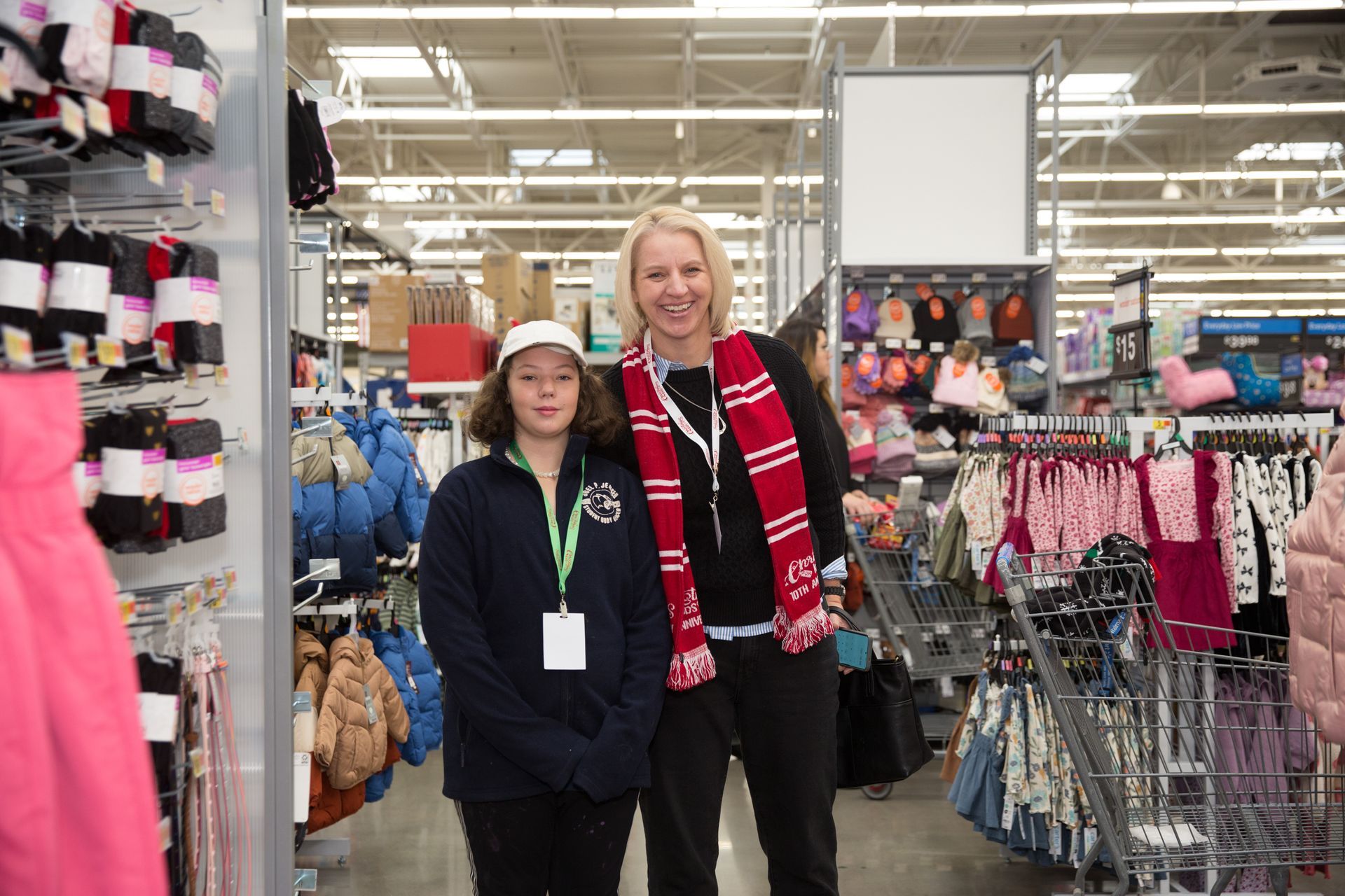 Two women are standing next to each other in a clothing store.